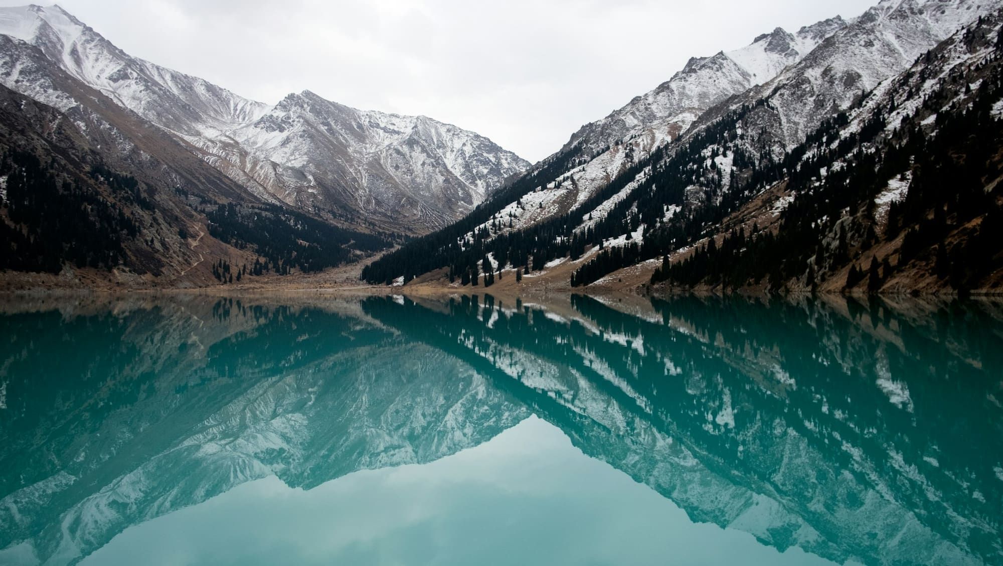Mountain lake surrounded by snow-covered peaks near Almaty, Kazakhstan